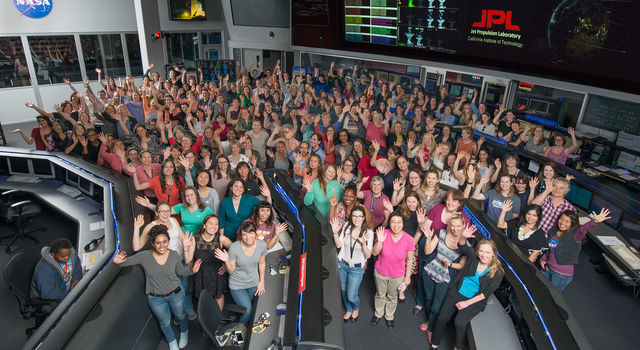 Women working in STEM at NASA's Jet Propulsion Laboratory pose for a photo in mission control in honor of Women in Science Day.