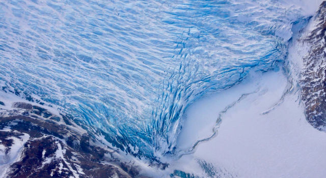 slide 1 - Cracks in the front of a glacier as it reaches the ocean