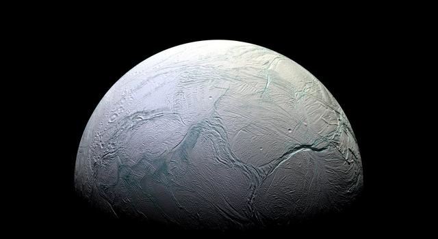 Image of Saturn's moon Enceladus covered in ice with giant cracks scarring its surface