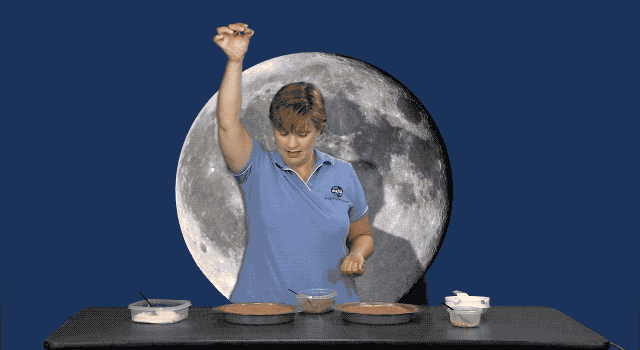 Animated image of a rock being dropped into a cake pan filled with ingredients meant to simulate the Moon's surface