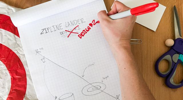 A person crosses out their first zipline lander design in red and writes "Design #2"