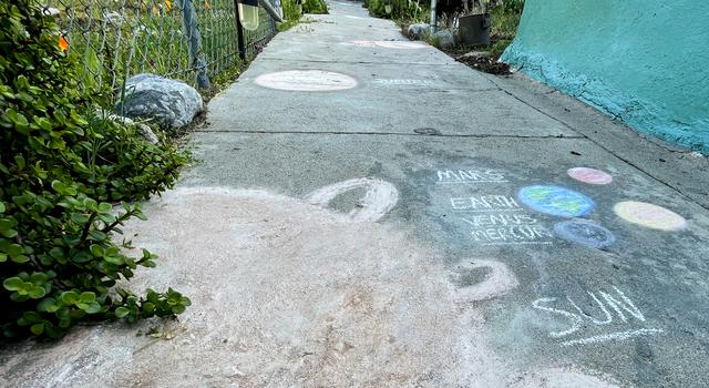 The Sun and planets drawn in chalk extend up a concrete walkway