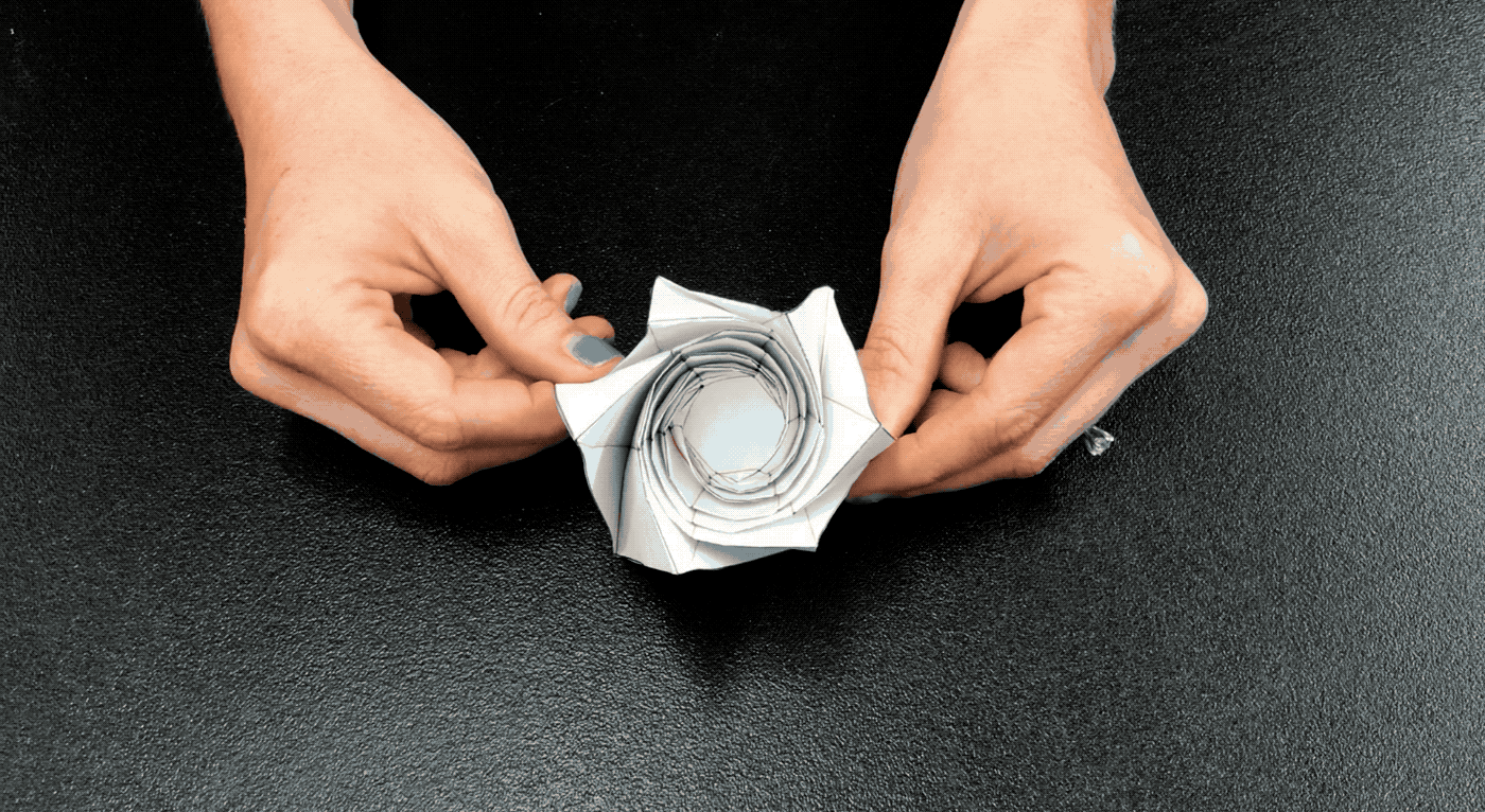 Animated image showing hands opening and closing the starshade origami model