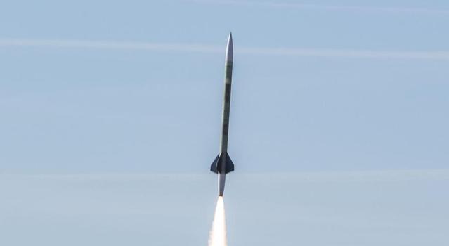 A rocket flies into a blue sky