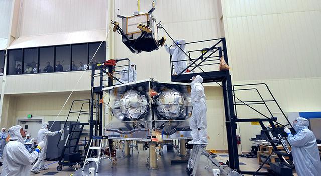 Technicians install a special radiation vault onto the propulsion module of NASA's Juno spacecraft at the Lockheed Martin facility in Denver, Colorado.