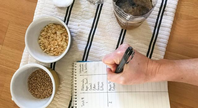 Photo of a person writing down a plan for a second version of their DIY water filter