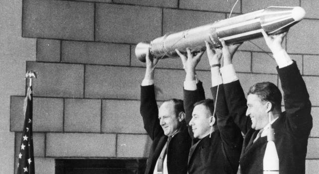 A model of Explorer 1 is held by (left to right) JPL Director William Pickering, University of Iowa physicist James Van Allen and Wernher von Braun from the Army Ballistic Missile Agency.