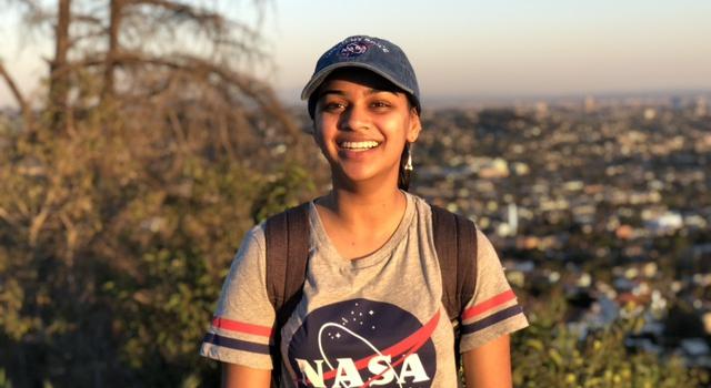 Natalie Deo poses for a photo wearing a shirt with a NASA meatball.