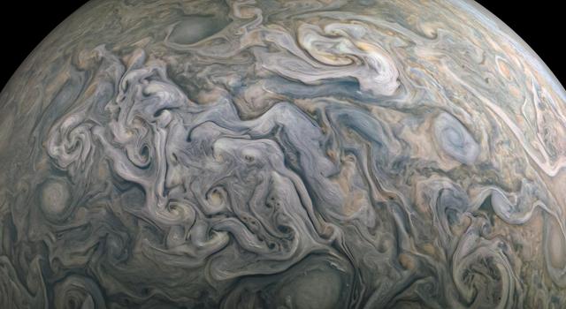 Close-up image of blue, tan and green swirling storms in Jupiter's atmosphere.